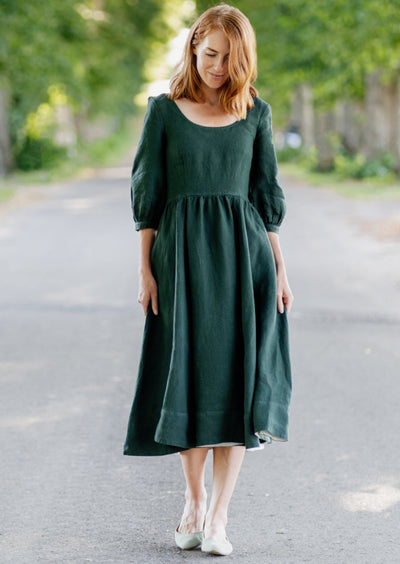 A lady walking along the road with a evergreen linen dress from Son de Flor