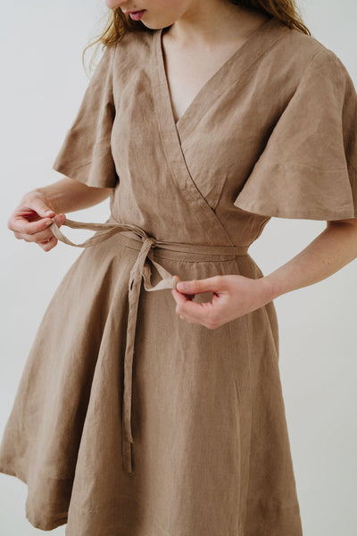Woman wearing Son de Flor hemp wrap dress with short sleeve in beige color