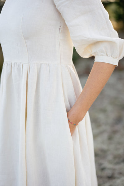 A lady showing the waist line of a Son de Flor milky white hemp dress